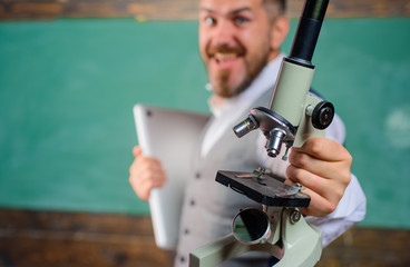 Education, science, scientific, research concept. Back to school. Happy student with laptop and microscope. Bearded man with notebook and microscope. Biology or chemistry concept. Selective focus.