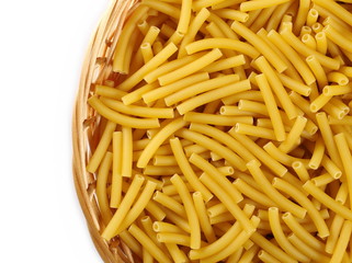 Macaroni, raw pasta in wooden food basket isolated on white background, top view