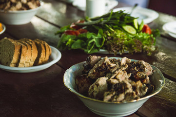 Vegetables and fruits are sliced on a wooden table. Picnic in the summer. Fresh vegetables. Party in nature.