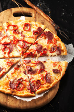 Tasty pepperoni pizza on a wooden board