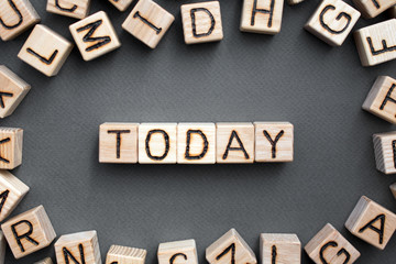 the word todey wooden cubes with burnt letters, gray background top view, scattered cubes around random letters