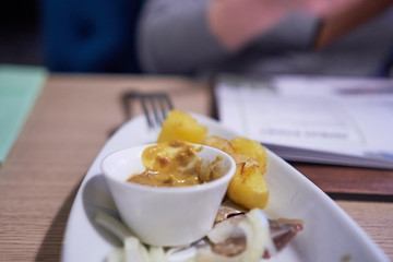 appetizer in a restaurant - onion, sauce, potatoes and herring