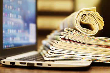 Newspapers and Laptop. Different Concepts for News - Social Network or Traditional Tabloid...