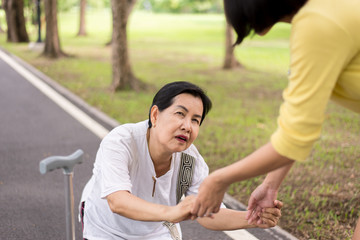 Senior asian woman with faint sitting on street after falling down,Take care and support concept
