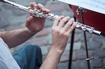 Closeup of hands on musician on flute  in tne street
