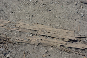 Old black and brown wooden bars from the railway line, broken and cracked by time. Very unique wooden background with unusual color under sunlight.