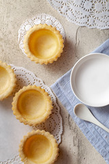 Empty tartlets and plate on table, top view.