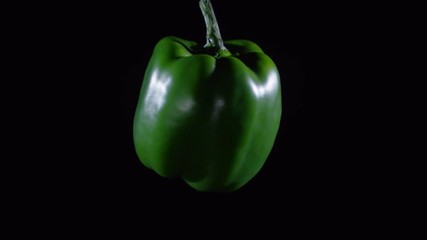 Close up of fresh green bell pepper floating and spinning on black background - Powered by Adobe