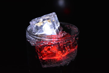 Very beautiful and stunning images of drinks with glowing ice cubes.  Bright colors with bubbles in a glass of champagne.  Promotional image of a relaxing, dear life and a tasty sparkling drink.