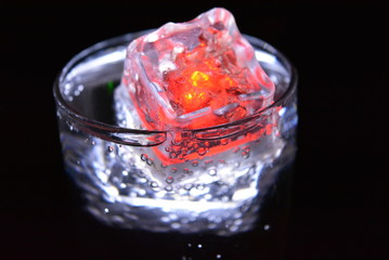 Very beautiful and stunning images of drinks with glowing ice cubes.  Bright colors with bubbles in a glass of champagne.  Promotional image of a relaxing, dear life and a tasty sparkling drink.