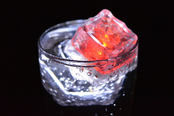 Very beautiful and stunning images of drinks with glowing ice cubes.  Bright colors with bubbles in a glass of champagne.  Promotional image of a relaxing, dear life and a tasty sparkling drink.