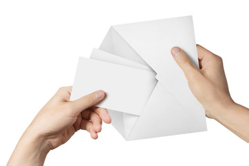 Hands pulling two blank sheets of paper (tickets, flyers, invitations, coupons, banknotes, etc.) out a white envelope, isolated on white background