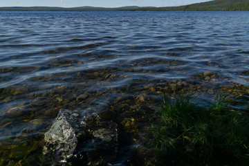The sky reflected in the waters of the northern lake and the rocky shores