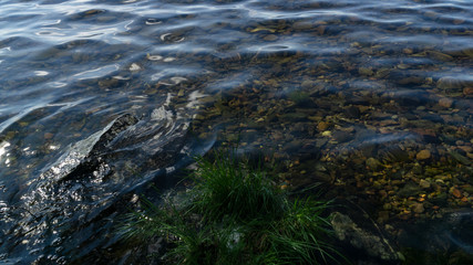 The sky reflected in the waters of the northern lake and the rocky shores