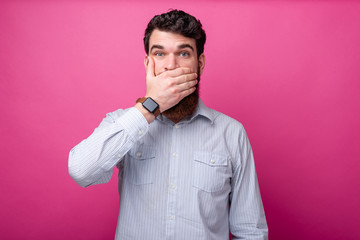 Shut your mouth! Man in casual covering mouth with hand
