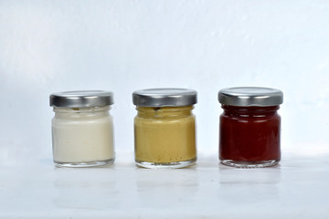 pots with mayonnaise mustard and ketchup on white background