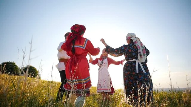 People in traditional russian clothes singing a song - walking in a circle