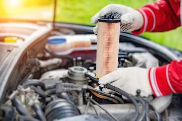 Specialist replaces the oil filter in the car.