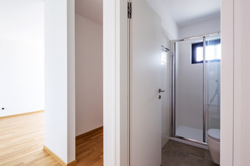 Modern minimalist white bathroom with shower and small window