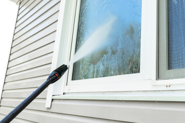 Cleaning service washing building facade and window with pressure water. Cleaning dirty wall with...