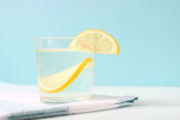 water with lemon on a colored background
