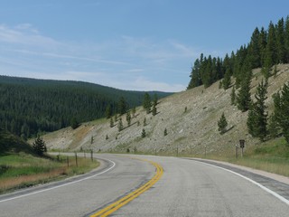 Fototapeta na wymiar Winding road along rolling hills at the Bighorn mountains in Wyoming.