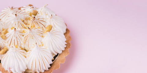 Fototapeta na wymiar Close-up of a lemon tart with italian meringue on pink backdrop