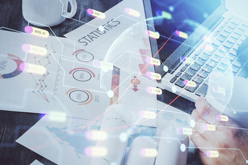 Double exposure of world map hologram with man working on computer on background. Concept of worldwideweb.