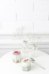 Fototapeta na wymiar Glass jar smoothies and baby breathes flower in vase on white table