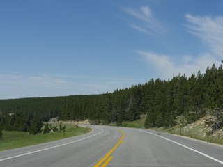 Medium close up of a curve in a smooth highway at Washakie County at Bighorn National Forest in Wyoming.