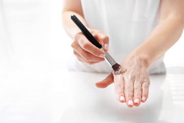Hand spa. The woman puts a mask on the skin of the hand. Hand skin care.