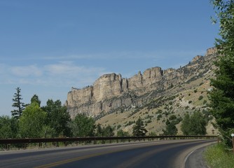 Dramatic granite cliffs and rock formations along a winding road at Bighorn Mountains in Wyoming.