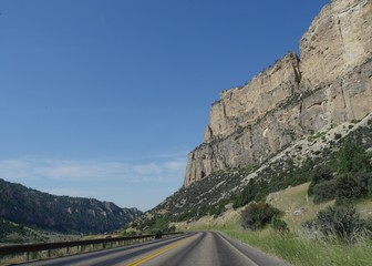 Fototapeta na wymiar Imposing rock wall cliffs and along a winding road through the Bighorn Mountains in Wyoming, USA.