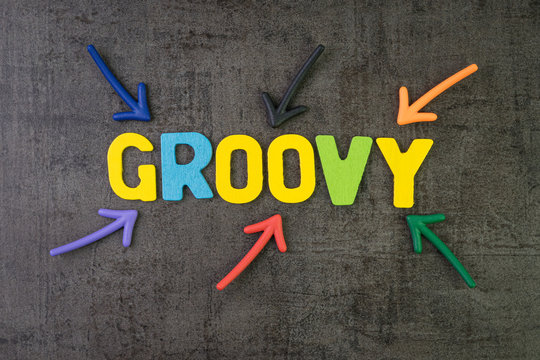 Groovy modern programming language for software development or application concept, multi color arrows pointing to the word Groovy at the center of black cement chalkboard wall