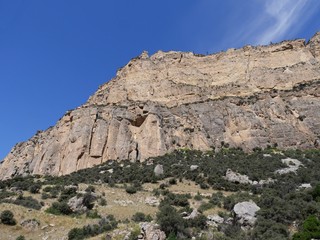Cropped shot of imposing rocky wall cliffs along the road through Bighorn Mountains in Wyoming, with beautiful clouds in the skies.