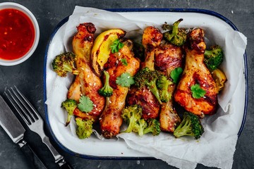 Baked chicken drumsticks with broccoli, cilantro, sesame and sweet chili sauce