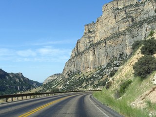 Scenic view along the road with high wall cliffs and ravines through the Bighorn Mountains in Wyoming, with beautiful clouds in the skies.