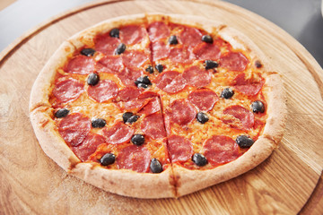 Olives, cheese and salami. Picture of prepared delicious pizza with sausage rings and olives