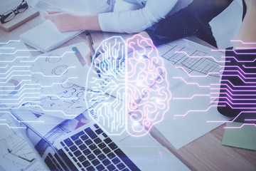 Double exposure of woman's writing hand on background with brain hud. Concept of learning.