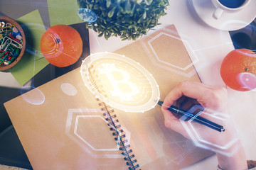 Cryptocurrency hologram over woman's hands writing background. Concept of blockchain. Multi exposure