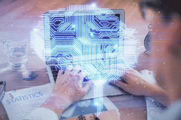 Man typing on keyboard background with brain hologram. Concept of big Data.