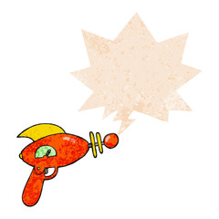 cartoon ray gun and speech bubble in retro textured style