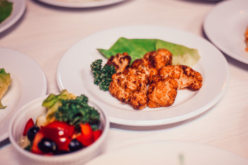 roasted cauliflower in breadcrumbs and vegetable salad on the table