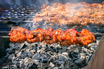 fresh hot grilled chicken shish kebab barbecue on grid over coal with smoke. Close-up