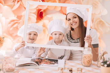 photo happy mom with children in the kitchen standing in front of the table