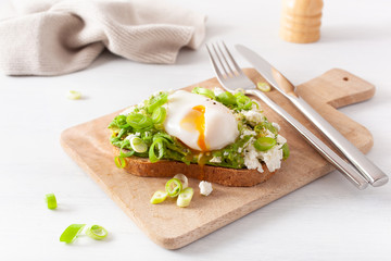 breakfast avocado sandwich with poached egg and feta cheese