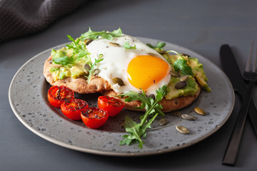Fototapeta na wymiar breakfast avocado sandwich with fried egg and tomato