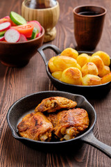 Roasted chicken thighs, fried potato and salad - rustic dinner