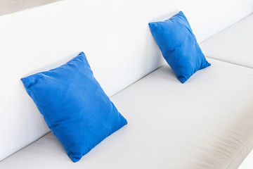 Blue cushions on a white sofa.