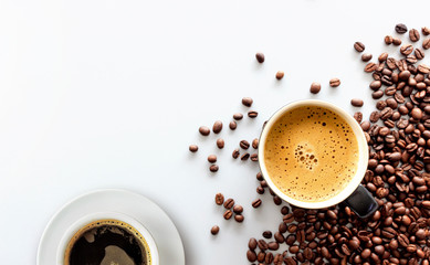 hot espresso and coffee bean on white table with soft-focus and over light in the background. top...